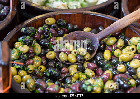 Oliven in Holzschalen mit Löffel servieren. Stockfoto