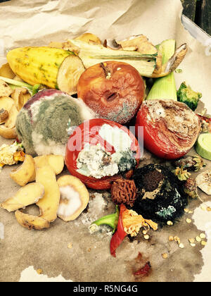 Schimmeliges Obst und Gemüse auf grauem Papier Stockfoto