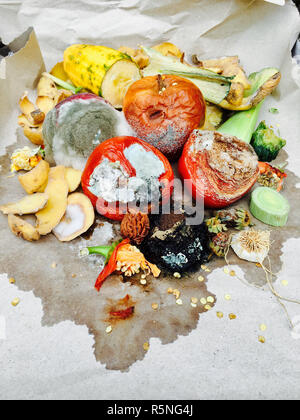 Schimmeliges Obst und Gemüse auf grauem Papier Stockfoto