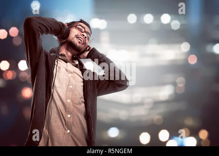 Asiatische junge Mann Musik über Kopfhörer zu hören Stockfoto