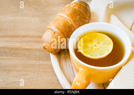 Frühstück mit frischen Croissants und Tasse Tee Stockfoto