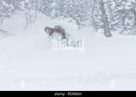 Mann, Snowboarder, Freerider geht auf Pulverschnee in den Bergen in einem Schneefall Stockfoto