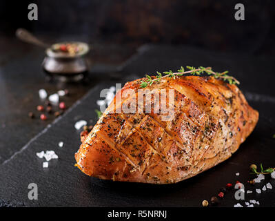 Gebratene Weihnachten Schinken aus der Türkei auf dunklen rustikalen Hintergrund. Festival Food. Stockfoto