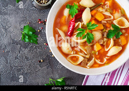 Minestrone, italienische Gemüsesuppe mit Nudeln auf den Tisch. Veganes essen. Ansicht von oben Stockfoto