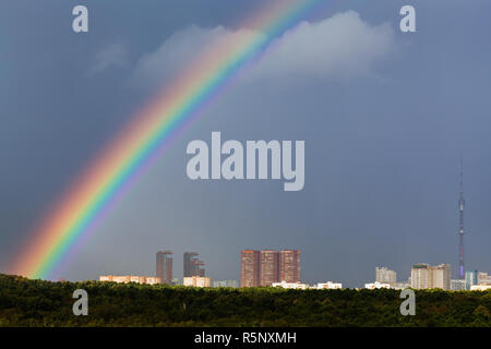 Rainbow im grauen Himmel über Stadt mit Fernsehturm Stockfoto