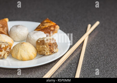 Leckeres Sortiment an hausgemachten Asiatische Gebäck. Samosas mit einer Blume und Banane Kugeln Stockfoto