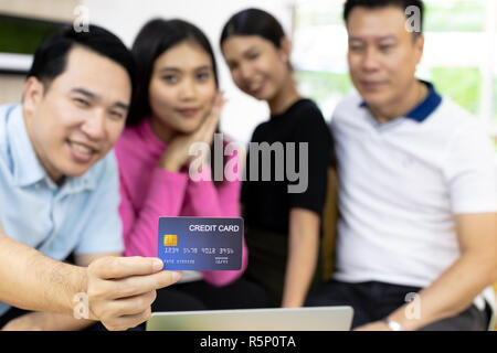 Junge freie Gruppe über eine Kreditkarte für die Zahlung im Cafe. Selektiver Fokus auf Kreditkarte Stockfoto