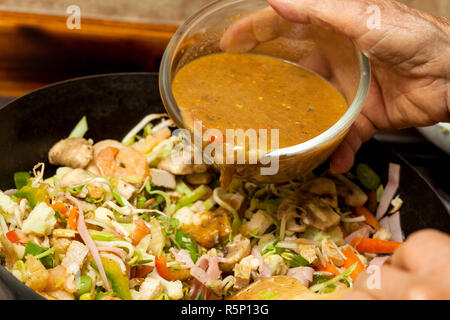 Sauteed Gemüse mit Huhn, Schwein, Marmelade und Shrimps Zubereitung: Hinzufügen Sauce zum Gemüse und Fleisch in einem Wok Stockfoto