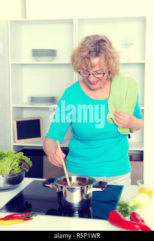 Blonde Frau, Kochen und Backen in der Küche Stockfoto