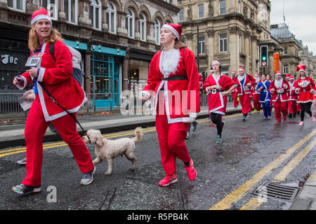 Liverpool, Merseyside, Großbritannien. November 2018. BTR Liverpool Santa Dash. Die Menschen in der ganzen Merseyside feiern die Rückkehr des größten festlichen 5-km-Laufs in Großbritannien. Die festliche Veranstaltung hat sich mit bis zu 10,000 Läufern, roten, blauen Santas, die in diesem Jahr teilnehmen, weiter entwickelt. Die Route führte die stürzenden Santas durch das Stadtzentrum, bevor sie die Ziellinie vor dem Rathaus überquerten, wo sie von unzähligen festlichen Charakteren begrüßt wurden. Quelle:MediaWorldImages/AlamyLiveNews. Stockfoto