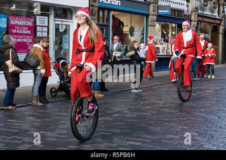 Chester, UK. 2. Dezember 2018. Zwei Wettbewerber auf einräder an den jährlichen Santa Strich durch die Straßen der Innenstadt. Credit: Andrew Paterson/Alamy leben Nachrichten Stockfoto