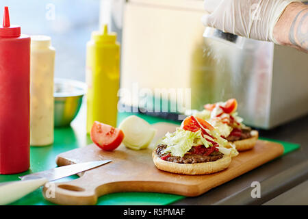 Frisch zubereitete offen zum Mitnehmen Burger auf einem Holzbrett Stockfoto