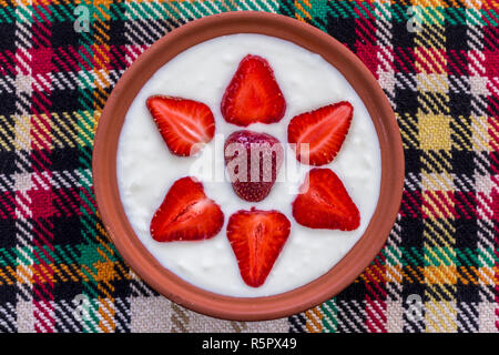 Erdbeeren in Scheiben geschnitten und schön in eine Schale mit Joghurt angeordnet. Stockfoto