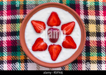 Erdbeeren in Scheiben geschnitten und schön in eine Schale mit Joghurt angeordnet. Stockfoto