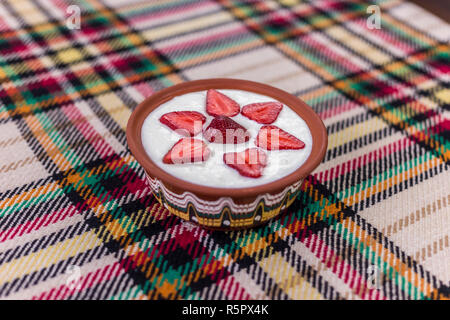 Erdbeeren in Scheiben geschnitten und schön in eine Schale mit Joghurt angeordnet. Stockfoto