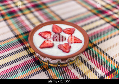 Erdbeeren in Scheiben geschnitten und schön in eine Schale mit Joghurt angeordnet. Stockfoto