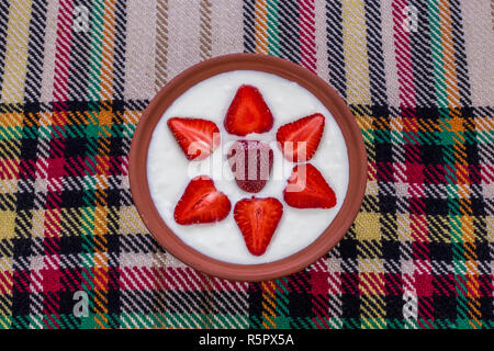 Erdbeeren in Scheiben geschnitten und schön in eine Schale mit Joghurt angeordnet. Stockfoto