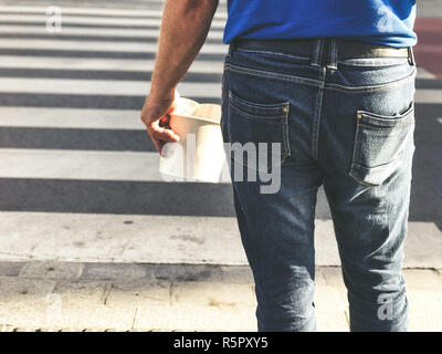 Ein Mann hält fast food in seiner Hand. Stockfoto