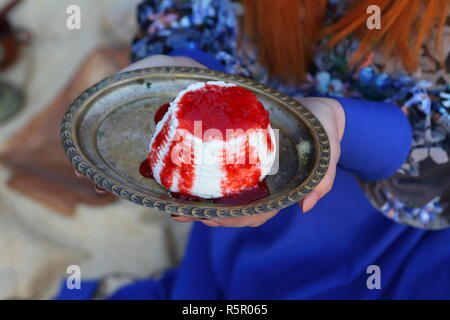 Frauen Hände halten eine Schale mit Ricotta gegossen Himbeermarmelade Stockfoto