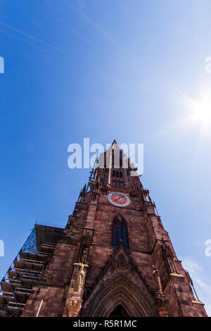 Low Angle View der Freiburger Münster Kathedrale an einem sonnigen Tag unter strahlend blauem Himmel. Freiburg im Breisgau, Baden-Württemberg, Deutschland Stockfoto