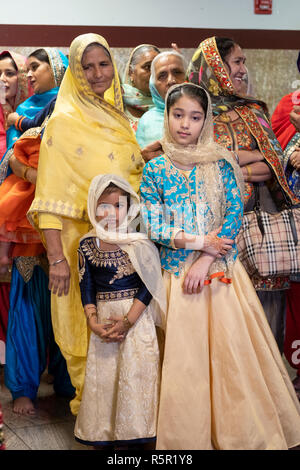 Frauen unterschiedlichen Alters an einem Sikh Hochzeit an einem Tempel in Richmond Hill, Queens, New York City. Stockfoto