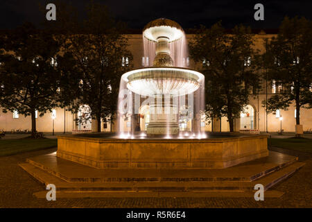 Beleuchtete Brunnen an der Geschwister-Scholl-Platz in München Stockfoto