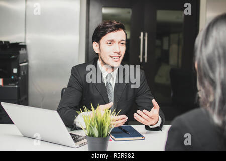 Lächelte und glücklich manager Geschäftsmann erklären, Einführung und Gespräch mit Unternehmerinnen über Neues Projekt. Stockfoto