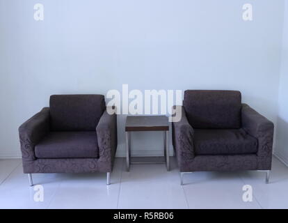 Zwei alte, leere Sessel und Couchtisch im Wohnzimmer Stockfoto