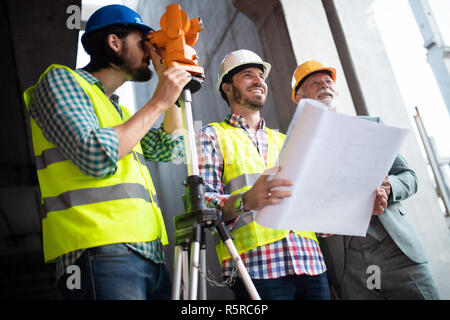 Mannschaft in Gruppe, Architekt und engeneer auf Baustelle Dokumente prüfen Stockfoto