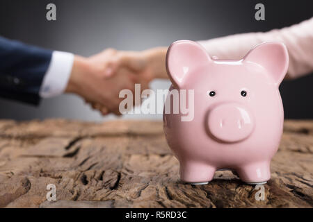 Rosa Sparschwein auf hölzernen Tisch Stockfoto