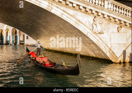 Gondel unter der Rialto Brücke bei Sonnenuntergang in Venedig, Italien am 27. November 2018 Stockfoto