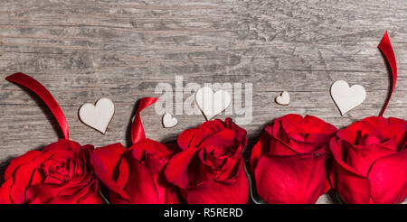 Rosen Bänder und Holz- Herzen auf Holz- Hintergrund, Valentines Tag Stockfoto