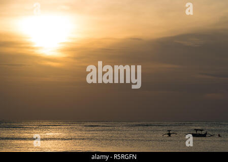 Sonnenuntergang auf Bali, Silhouetten von Fischerbooten Stockfoto