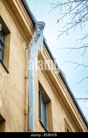 Winter Eiszapfen hängen an ein Fallrohr. Winter Gefahr fallender Eiszapfen von den Dächern Stockfoto