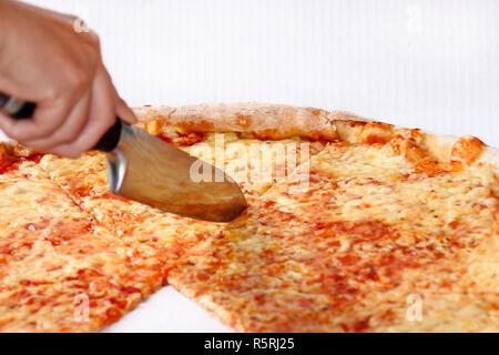 Frau mit einem Messer schneiden der Pizza. Leckere Pizza Margarita. Nehmen Sie frisch gebackene Pizza in einer Box gehalten wird, aus der Nähe. Stockfoto