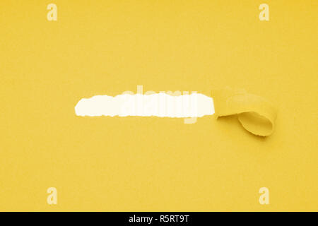 Loch zerrissen in gelbes Papier versteckte Kopie Raum zu zeigen Stockfoto