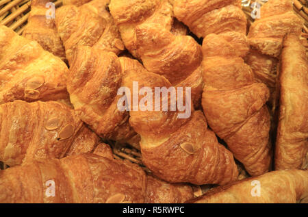 Stapel von frisch gebackenen leckeren almond Croissants Gebäck in den Korb Stockfoto