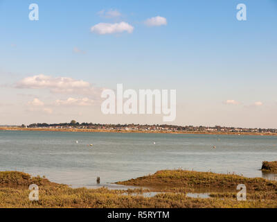 Schöne Szene der Fluss mit Booten Wiese vor blauem Himmel und Wolken Dorf Skyline im Hintergrund Stockfoto