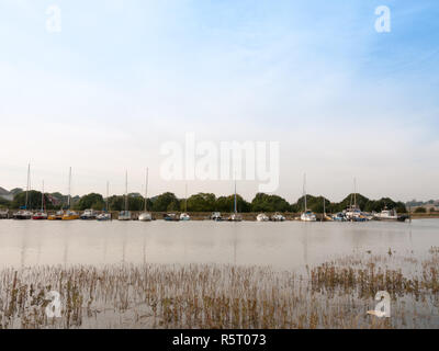 Zeile der geparkten Boote auf dem Fluss auf der anderen Straßenseite Stockfoto