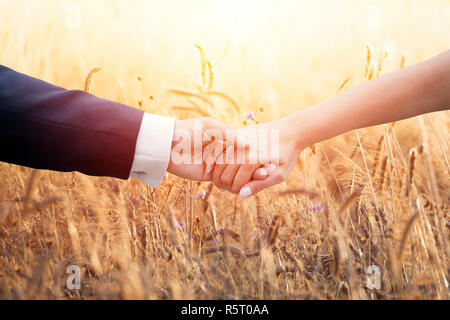 Hochzeit paar hält die Hände über die Ohren von Mais Stockfoto