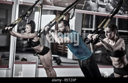 Sportliche Leute, crossfit Training mit trx Träger Stockfoto