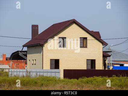 Das Haus mit Kunststoff Fenstern und einem Dach aus Wellblech Stockfoto