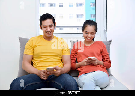 Jungen asiatischen Paar zusammen entspannen mit mit Handy Stockfoto