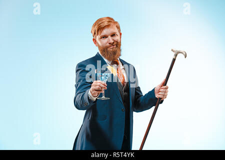 Die barded Mann im Anzug holding Zuckerrohr. Stockfoto