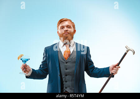 Die barded Mann im Anzug holding Zuckerrohr. Stockfoto