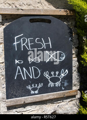 Frischer Fisch und Krabben Kreidetafel Zeichen außerhalb des Scott Arms Pub in Kingston, Purbeck, Dorset, England, Großbritannien Stockfoto