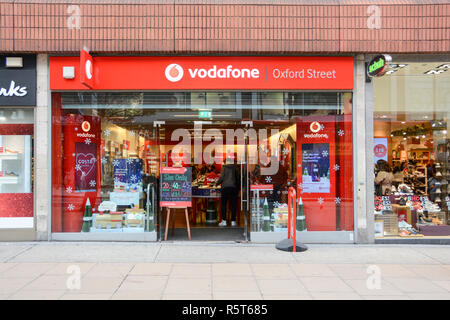 Vodaphone mobile network operator Logo und Beschilderung außerhalb der Oxford Street, London, UK Stockfoto