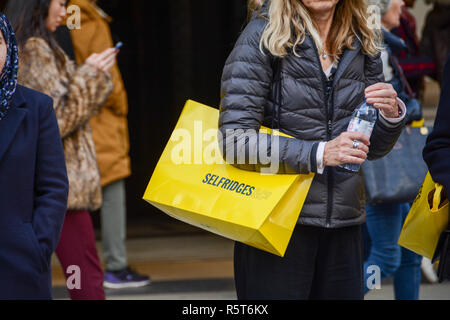 Käufer, die Kaufhaus Selfridges Papier tragetaschen, Oxford Street, London, UK Stockfoto