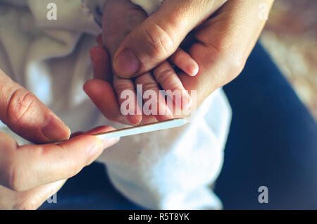 Einreichung Nägel neugeborenen vermeiden Sie Kratzer - baby Nagel Datei ausschneiden Stockfoto