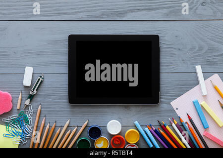 Schule Hintergrund, kid Studie liefert und digitale tablet Mock up Bildschirm grau grau Holz- Hintergrund, neue online Educational Web Technologien applic Stockfoto